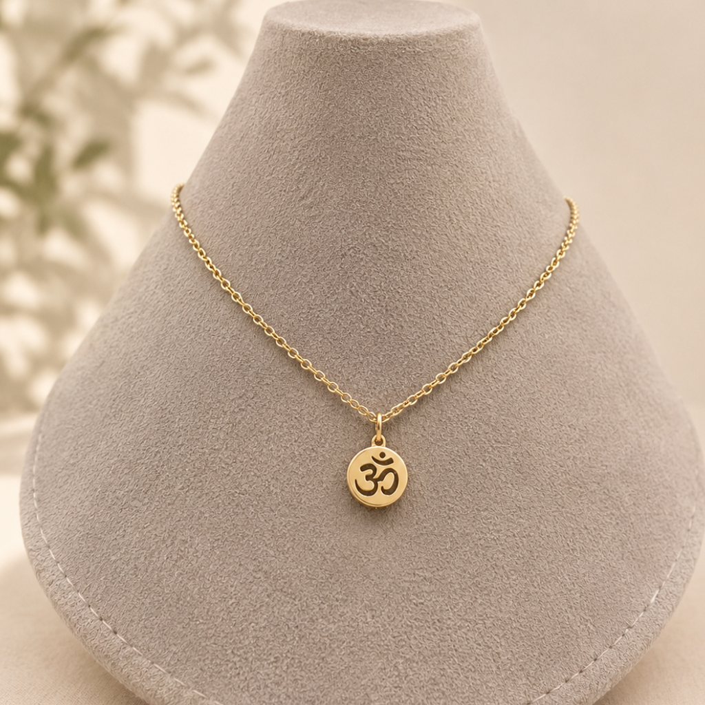 A delicate gold chain necklace with an Om symbol pendant.